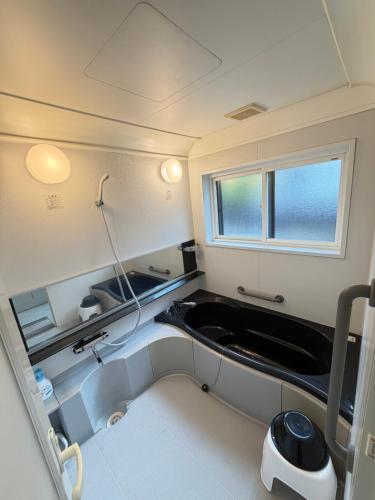 a small bathroom with a sink and a tub at 雅ストリートハウス角館 in Senboku