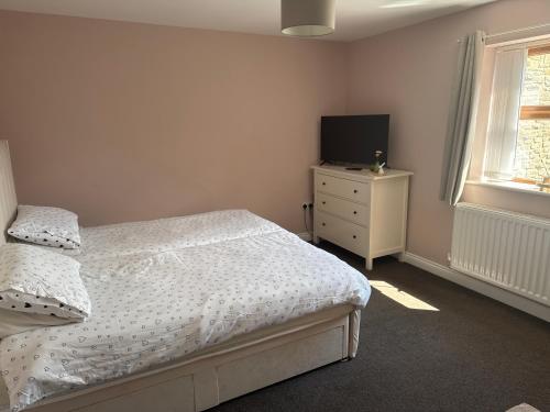 a bedroom with a bed and a television on a dresser at Thornley pit house farm in Durham