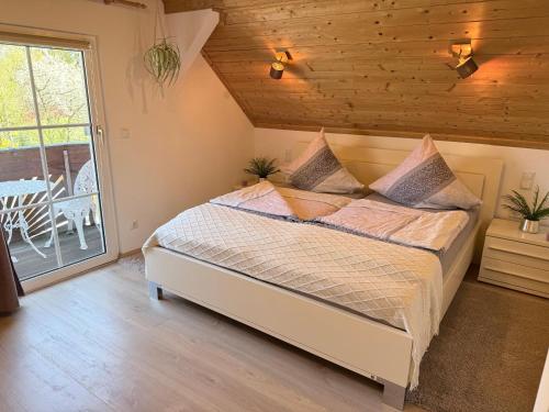 a bedroom with a bed and a balcony with a table at Fichtelfeeling in Fichtelberg