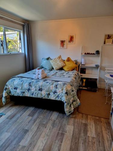 a bedroom with a bed with stuffed animals on it at Sun Republik Studio in Whitianga