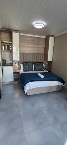 a bedroom with a large bed with a blue blanket at Reef View BnB in East London