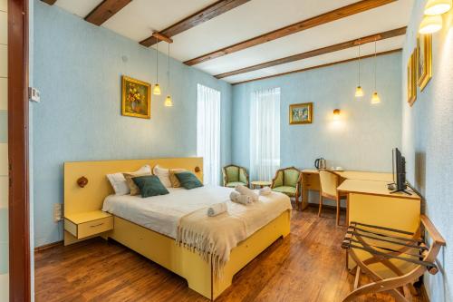 a bedroom with a bed and a table and a desk at Cherry Tree Sibiu in Sibiu