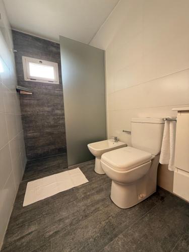 a bathroom with a toilet and a shower at Treffen Cabañas in Villa General Belgrano