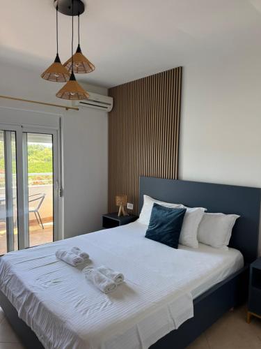 a bedroom with a large bed with towels on it at Sunrise house apartments in Ulcinj