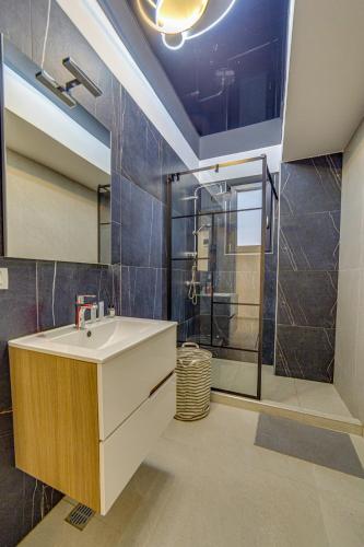 a bathroom with a sink and a shower at Apartaments PopDan Residence by the Sea in Eforie Nord