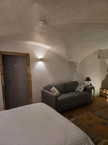 a bedroom with a bed and a couch in a room at La Tour Noble in Saint-Saturnin