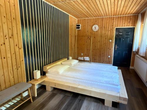 a bedroom with a large bed in a wooden wall at Cabana Plai in Petroşani