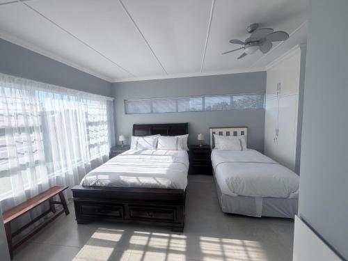 a bedroom with two beds and a ceiling fan at CCV Beach House in Bay View