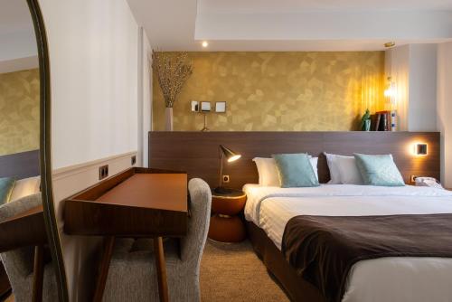 a hotel room with two beds and a desk at Hotel Parc Eiffel in Paris