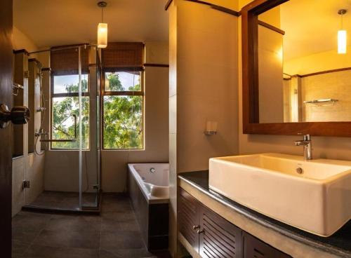 a bathroom with a sink and a shower and a tub at Rock Wild Yala in Yala
