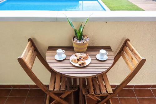 a table with a plate of food and a plant at Fenals Calm - con piscina in Lloret de Mar