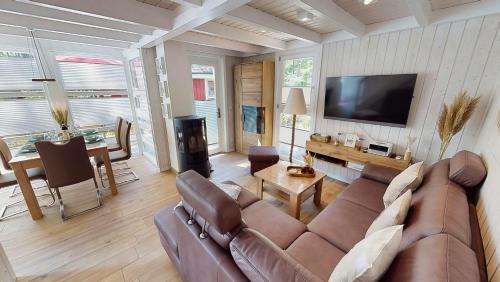 a living room with a couch and a television at Strandhaus Rügenperle - Baabe in Baabe