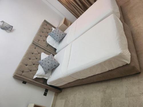 a bed with two pillows on it in a room at Appartement Aéroport Palm Marrakech-M9 in Marrakesh