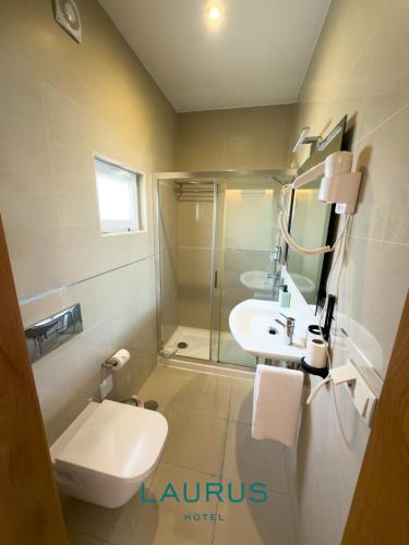 ein Badezimmer mit Toilette, Waschbecken und Dusche in der Unterkunft Laurus Hotel in Lourinhã