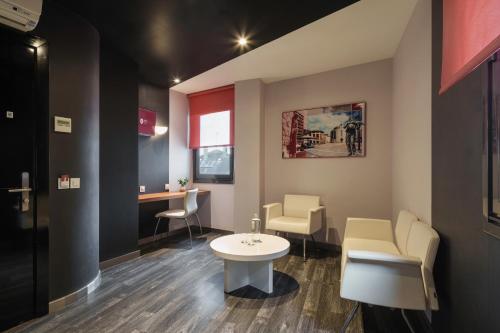 a waiting room with a white table and chairs at Exe Hotel El Magistral in Oviedo