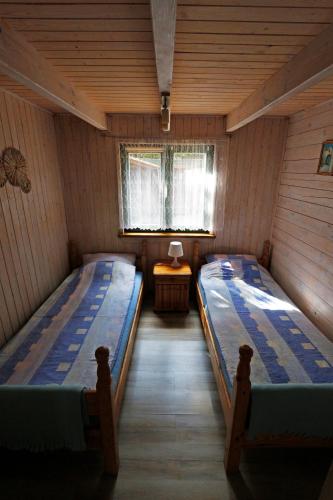 a room with two beds in a wooden house at Domki nad Jeziorem Ołów in Ryn