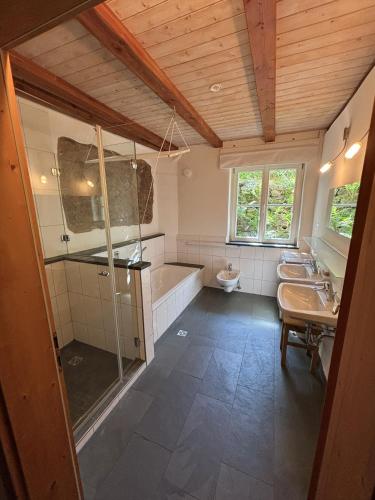 a bathroom with three sinks and a tub and a toilet at Auf der Saarinsel in Kanzem