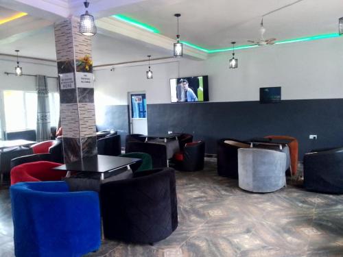 a restaurant with chairs and tables and a counter at Palmgroove Hotel AND Bar, IDANYIN, IPERIN,OGUN STATE in Obisesan