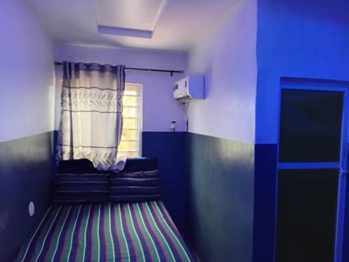 a living room with a couch and a window at Palmgroove Hotel AND Bar, IDANYIN, IPERIN,OGUN STATE in Obisesan
