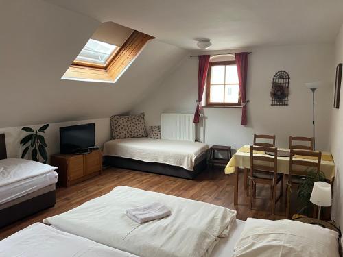 a room with two beds and a table and a television at ubytování U Šeniglů in Telč