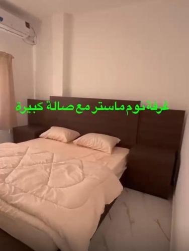 a bedroom with a bed with a sign on it at Airport Chalet مزرعة وشاليه المطار in Amman