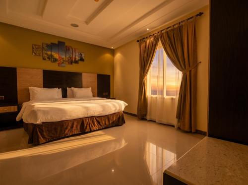 a bedroom with a large bed and a window at Tulip Al Rawda Serviced Apartments in Riyadh