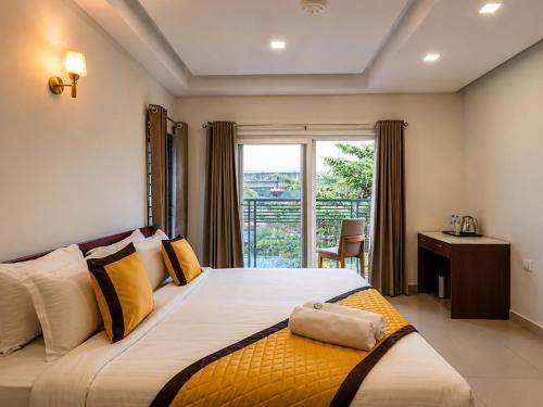 a bedroom with a bed with a window and a desk at K Grandeur Hotels- South Railway Station in Cochin