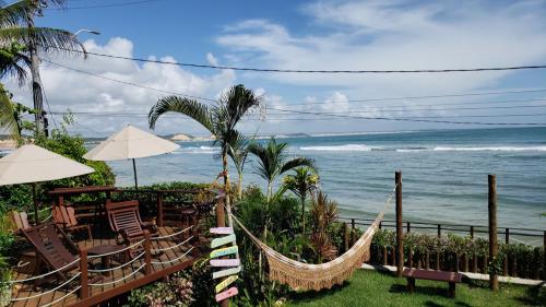 a beach with chairs and hammocks and the ocean at Casa Serena in Pipa