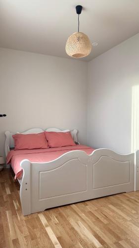 a bedroom with a white bed with pink sheets at Türi Cozy Apartment in Türi