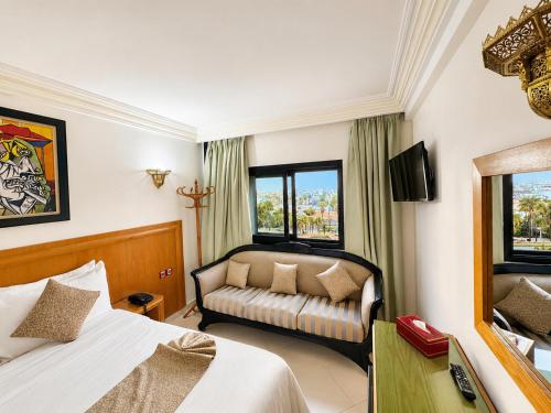 a hotel room with a bed and a couch at Majliss Hotel Downtown in Rabat