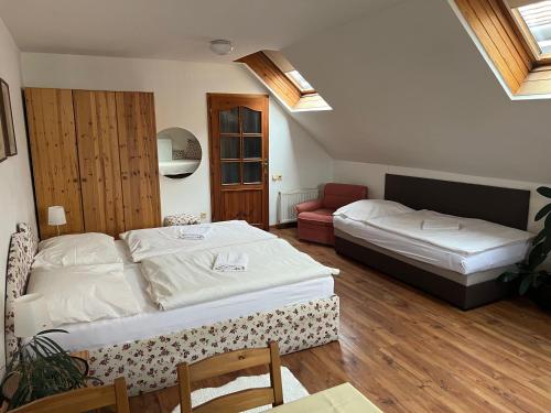 a bedroom with two beds and a chair in it at ubytování U Šeniglů in Telč