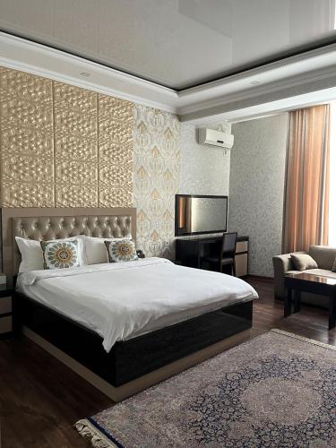 a bedroom with a bed and a desk and a couch at Sunrise Apartments in Dushanbe