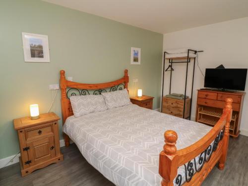 una camera da letto con un letto in legno e una televisione di Barlings a Lincoln