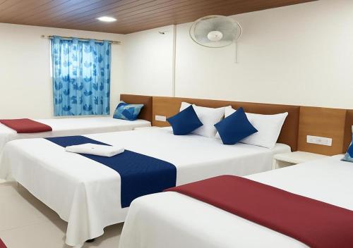 a room with two beds with blue and white pillows at Hotel yogeshwar in Mahesāna