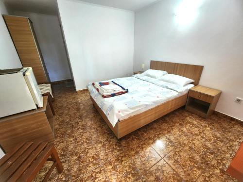 a bedroom with a large bed with a wooden frame at La Livadă in Vama Veche