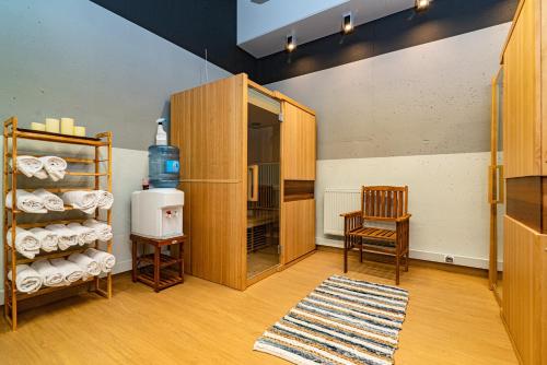 a room with a chair and a shelf with towels at Hotel Szafran in Czeladź