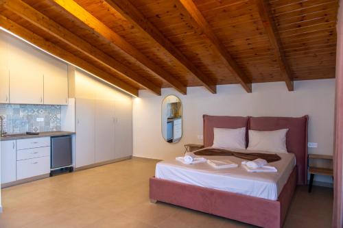 a bedroom with a large bed and a kitchen at PERDIKA's HORIZON in Perdika