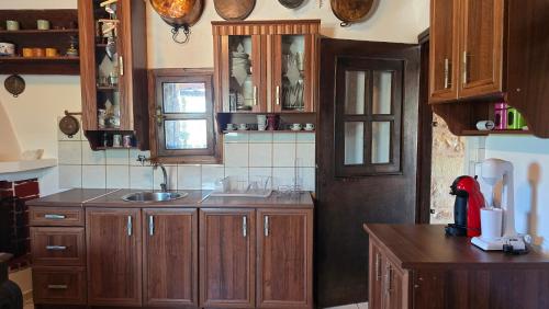 a kitchen with wooden cabinets and a sink at Lekania House in Káto Nisí