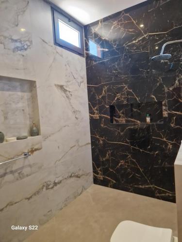 a bathroom with a black and white marble wall at Agadir sans vis a vis in Bouria