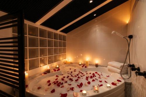 a bathroom with a tub filled with flowers and candles at Grace Suite with Jacuzzi Wonderful Lakefront View in Colonno