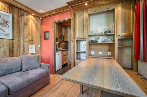 a living room with a couch and a wooden table at Appartement Tommeuse 93 in Tignes
