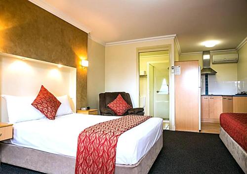 a hotel room with a bed and a chair at Motel Carnarvon in Roma