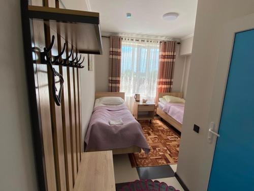 a small bedroom with two beds and a window at Khan-toru in Pokrovka