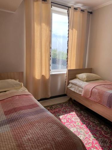 a bedroom with two beds and a window at Khan-toru in Pokrovka