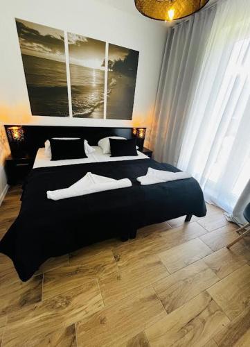 a bedroom with two beds with black and white pillows at Tesao Room by Dworek Marino in Grzybowo