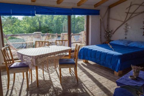 a bedroom with a bed and a table and chairs at ECO Beach Houses - Pet friendly in Peroj