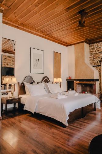 a bedroom with a large bed and a wooden ceiling at Palea Poli Boutique Hotel in Naousa