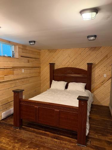 a wooden bed in a room with wooden walls at Urban Midtown Stays in St. John's