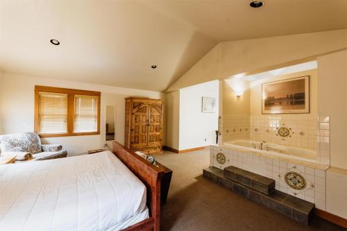 a bedroom with a bed and a bath tub at Chico Hot Springs Resort in White City