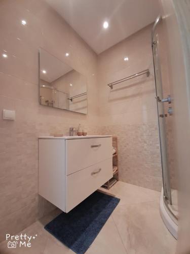 a bathroom with a white sink and a shower at Chaleureux appartement in Bouznika
